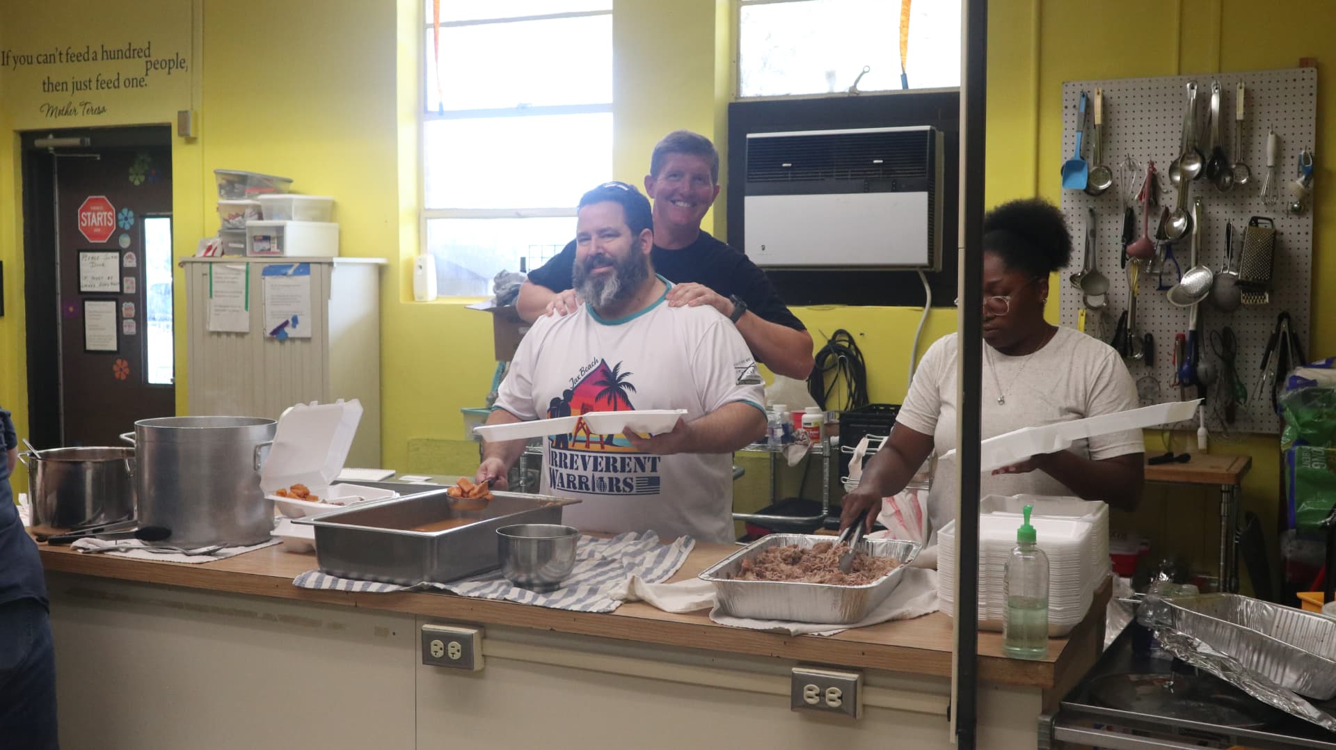 Veterans Phalanx volunteers serving plates together during Team Mess Hall at Gracie's Kitchen.