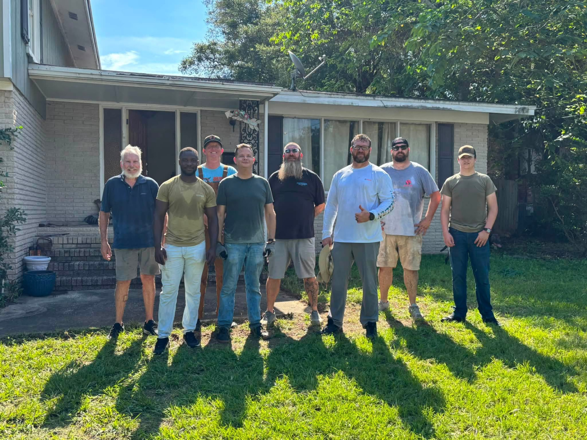 The Veterans Phalanx volunteer crew standing in the front yard of a veteran household after completing a Next Objective: Homefront property cleanup.