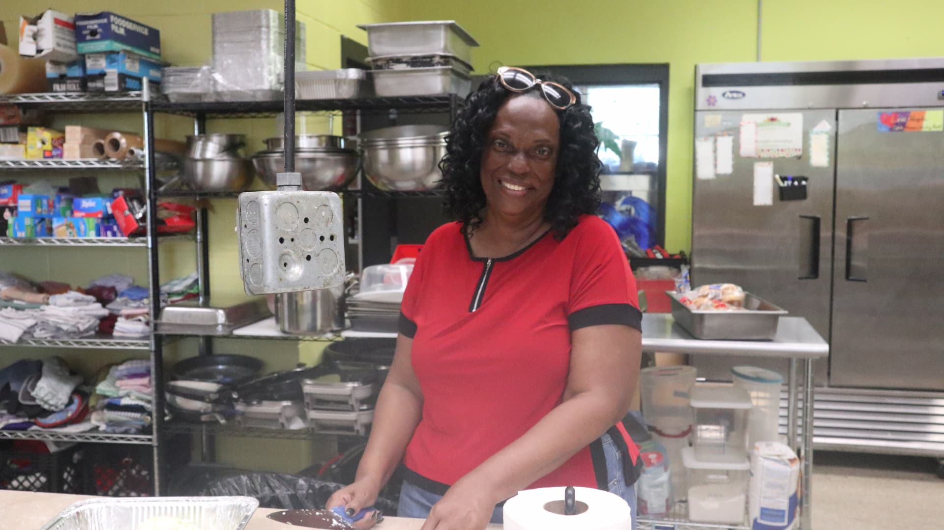 A Gracie's Kitchen partner smiling while preparing food during Team Mess Hall.