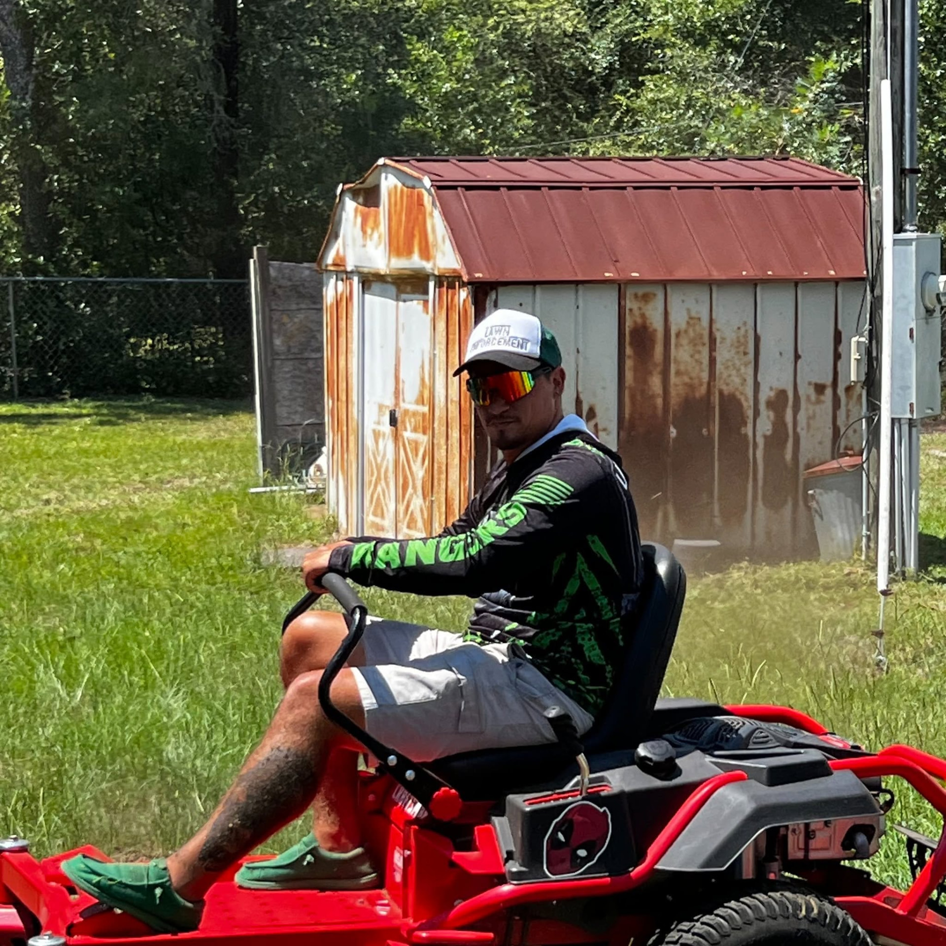 A Lawn Rangers crew member mowing the yard of an 81-year-old veteran during a Next Objective: Homefront request.